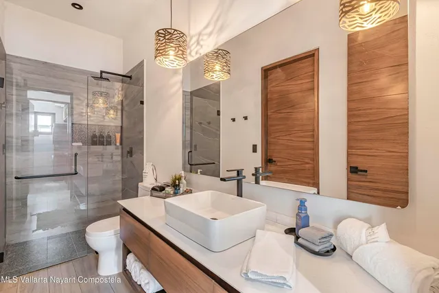 a bathroom with a sink a toilet and shower