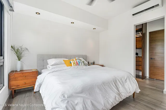 a bedroom with a bed and wooden floor