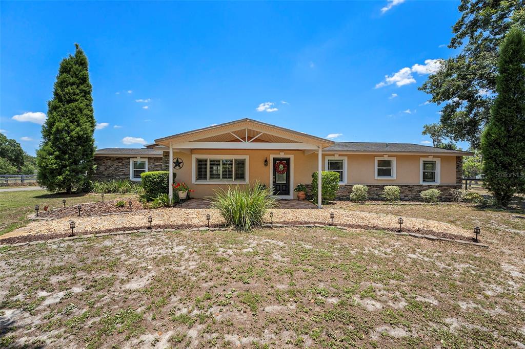 a front view of a house with a garden