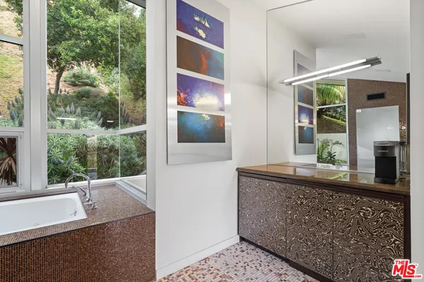 a bathroom with a double vanity sink a mirror and a bathtub