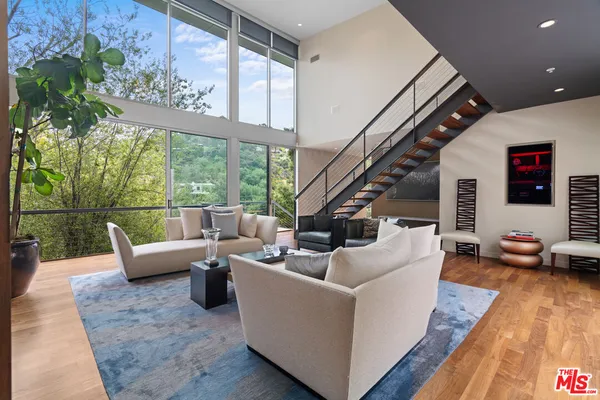 a living room with fireplace furniture and a large window