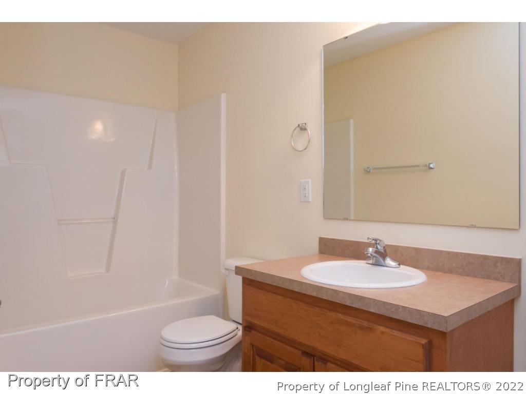 3689 Old Stage Road North Angier, NC 27501 - Photo 14 of 25 a bathroom with a sink a toilet and a mirror