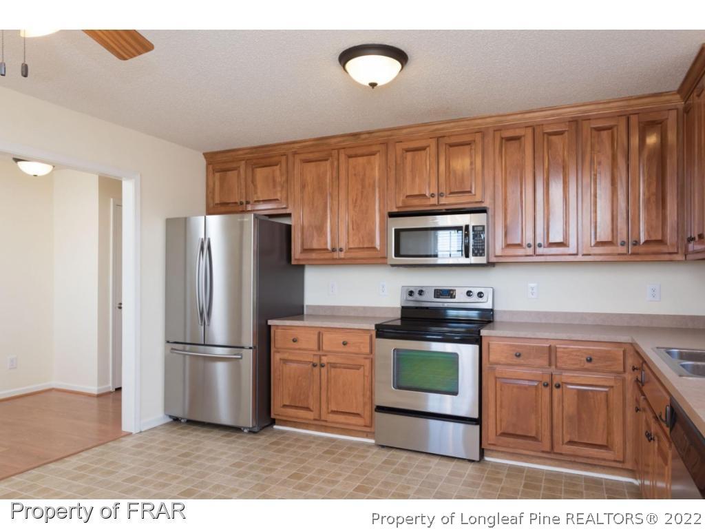 3689 Old Stage Road North Angier, NC 27501 - Photo 9 of 25 a kitchen with wooden cabinets and stainless steel appliances