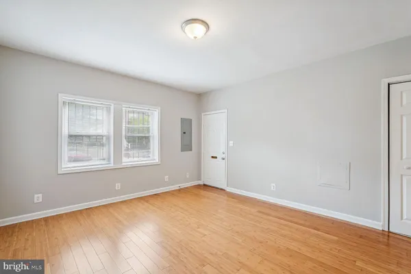 an empty room with wooden floor and windows