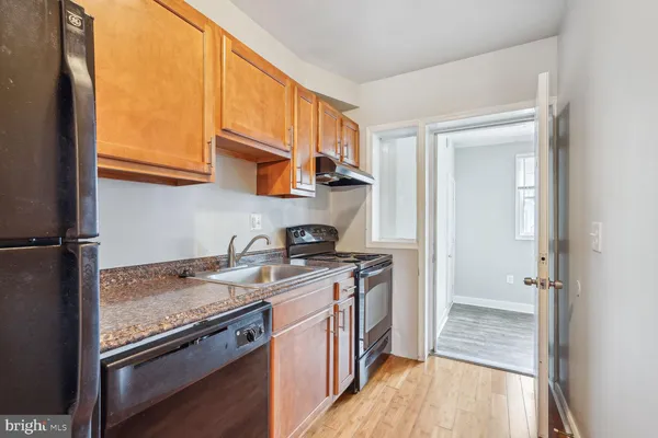 a kitchen with a sink stove top oven and cabinets