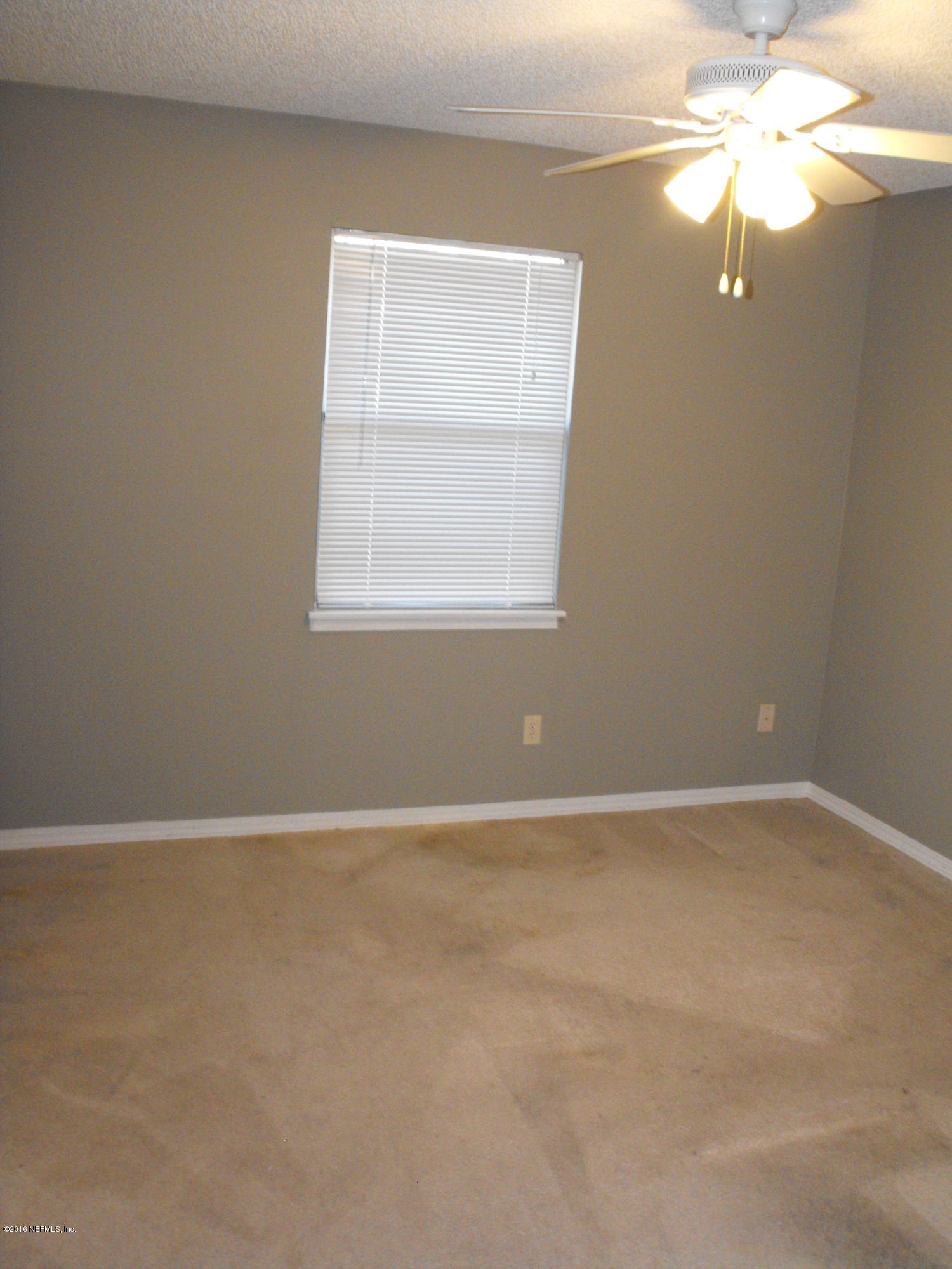 1543 Derringer Road Jacksonville, FL 32225 - Photo 8 of 19 an empty room with windows and fan