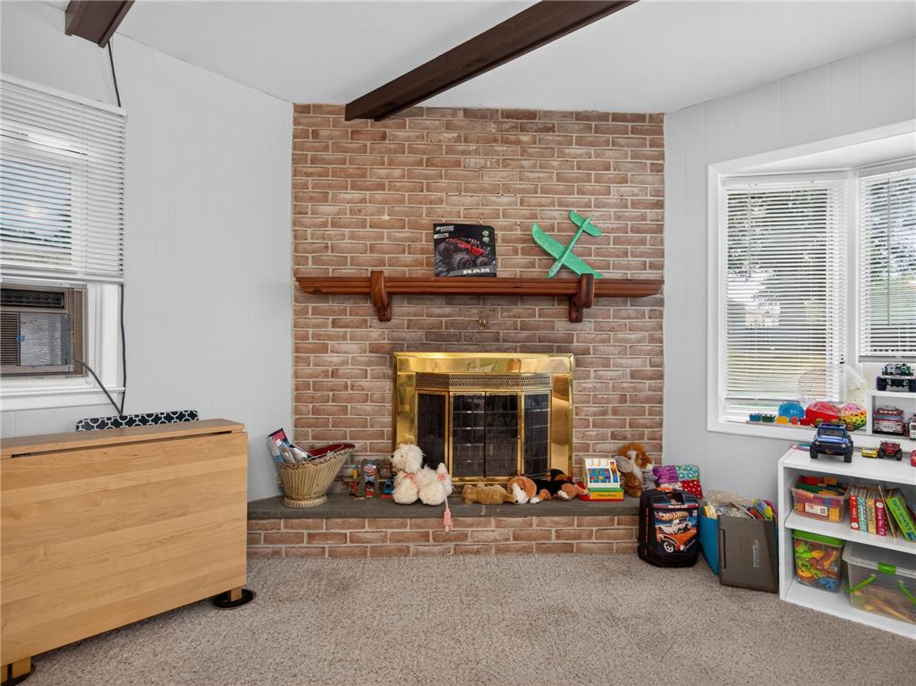 3046 Ridon Court Bethlehem, PA 18020 - Photo 21 of 41 A welcoming living space features a charming brick fireplace with a golden firebox, perfect for cozy evenings.