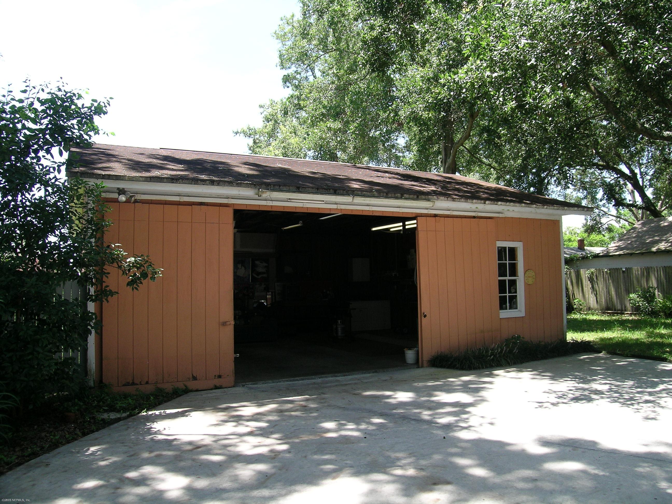 4622 Manchester Road Jacksonville, FL 32210 - Photo 2 of 9 a backyard of a house with large trees and table and chairs