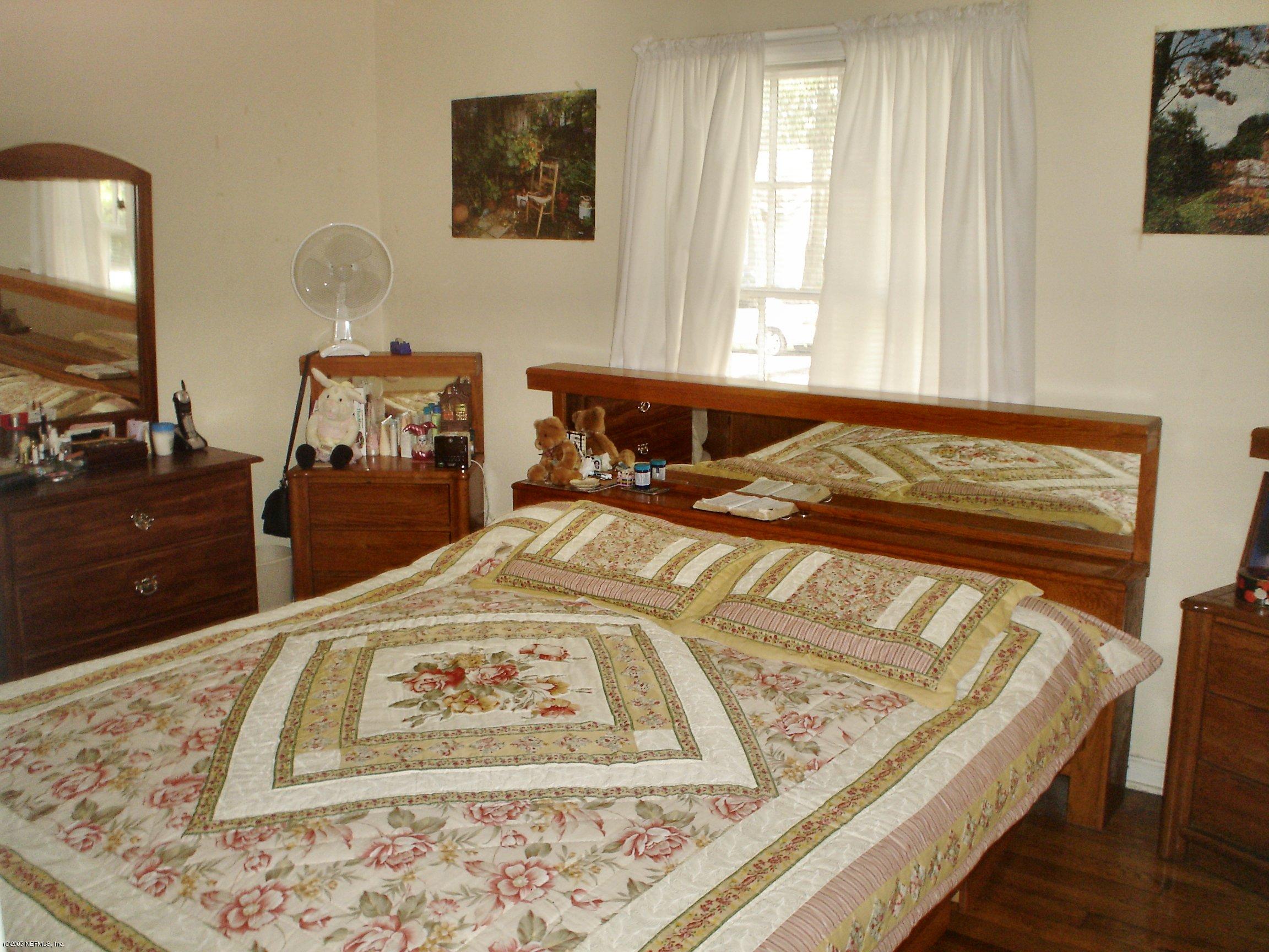 4622 Manchester Road Jacksonville, FL 32210 - Photo 6 of 9 a bed sitting in a bedroom next to a window