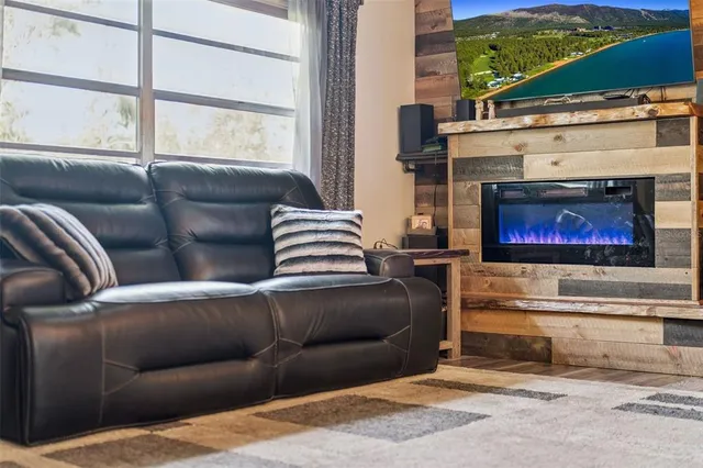 a living room with furniture a fireplace and a floor to ceiling window