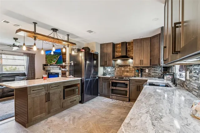 a kitchen with stainless steel appliances granite countertop a sink stove and refrigerator