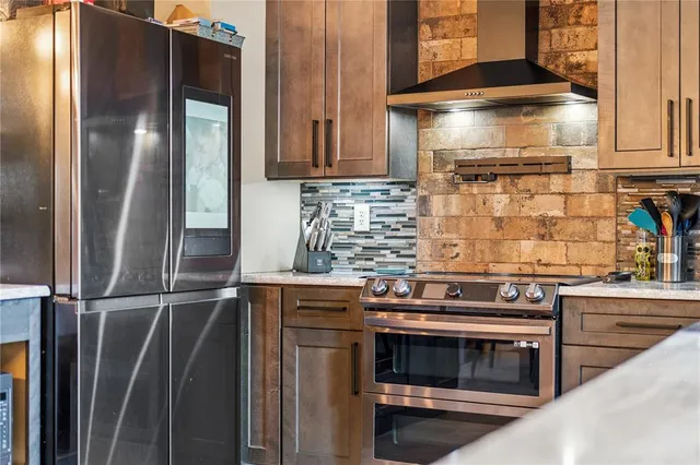 a kitchen with stainless steel appliances granite countertop a stove and a refrigerator