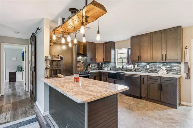 a kitchen with a stove a sink a kitchen island with wooden cabinets and floor