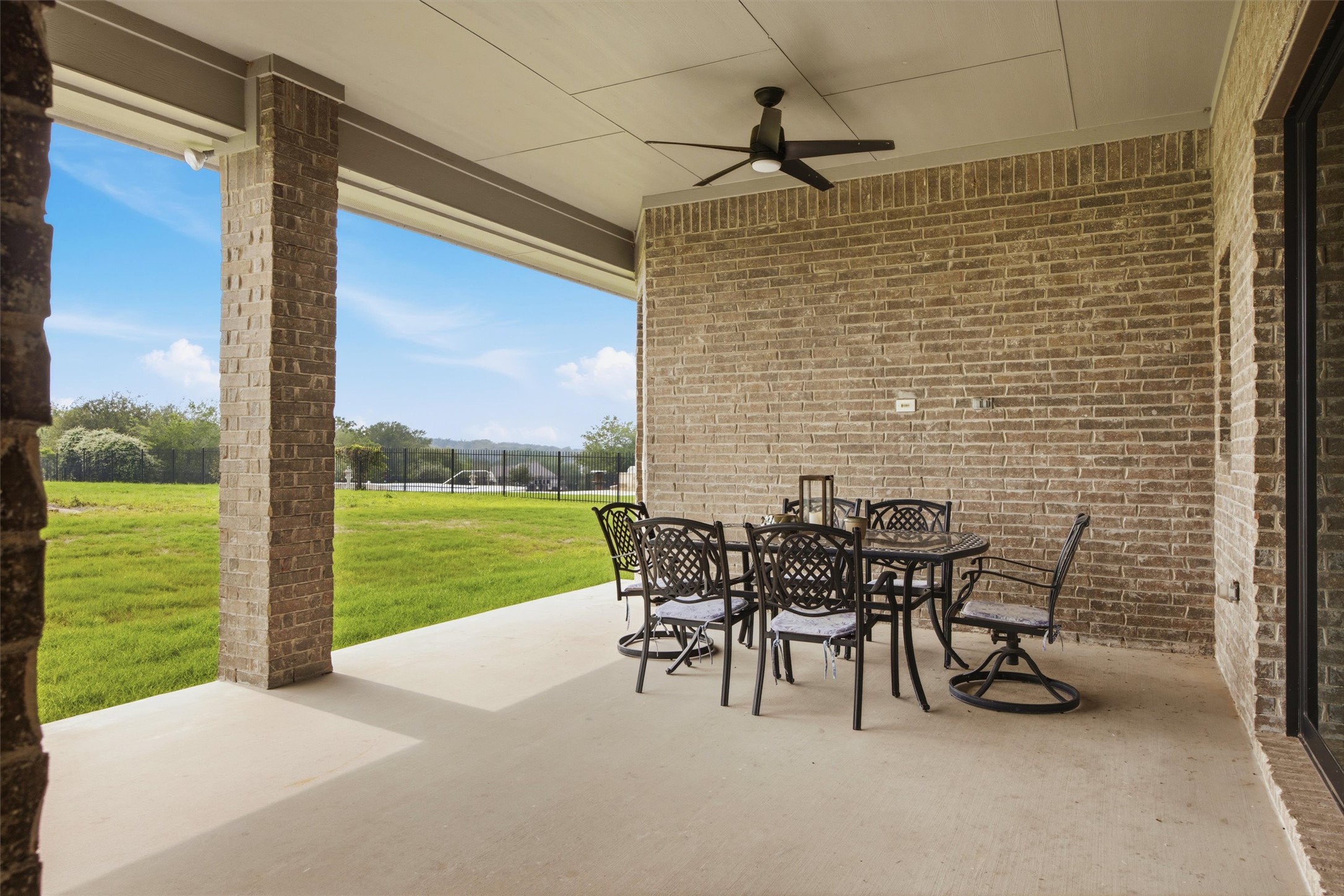 192 Raptor Beak Way Cedar Creek, TX 78612 - Photo 32 of 38 Covered patio featuring brick columns and exterior wall, an integrated ceiling fan, and a concrete floor