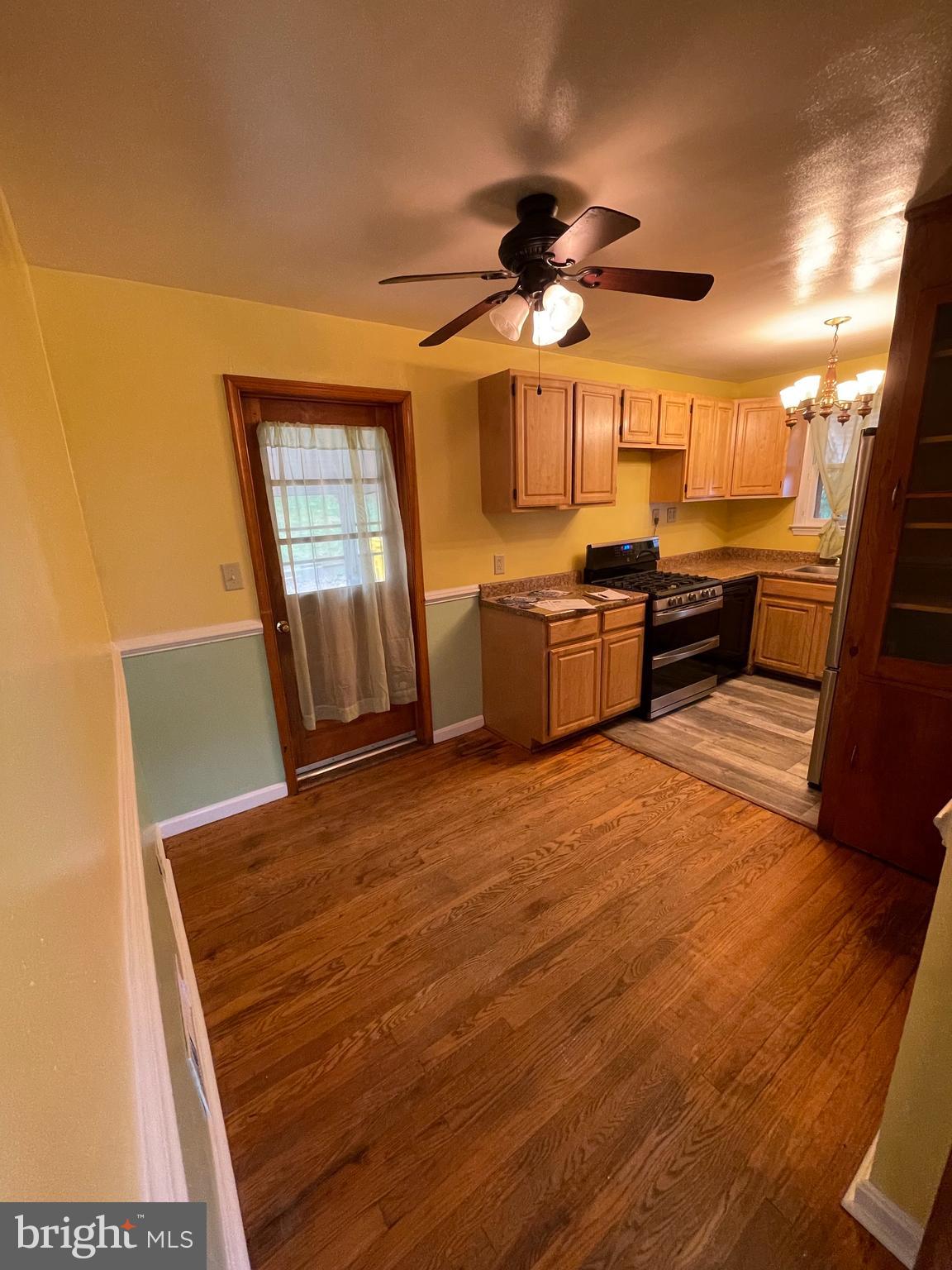 415 West Maple Road Linthicum Heights, MD 21090 - Photo 3 of 12 a large kitchen with a wooden floor and stainless steel appliances