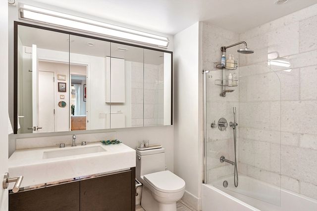 a bathroom with a sink toilet vanity and shower