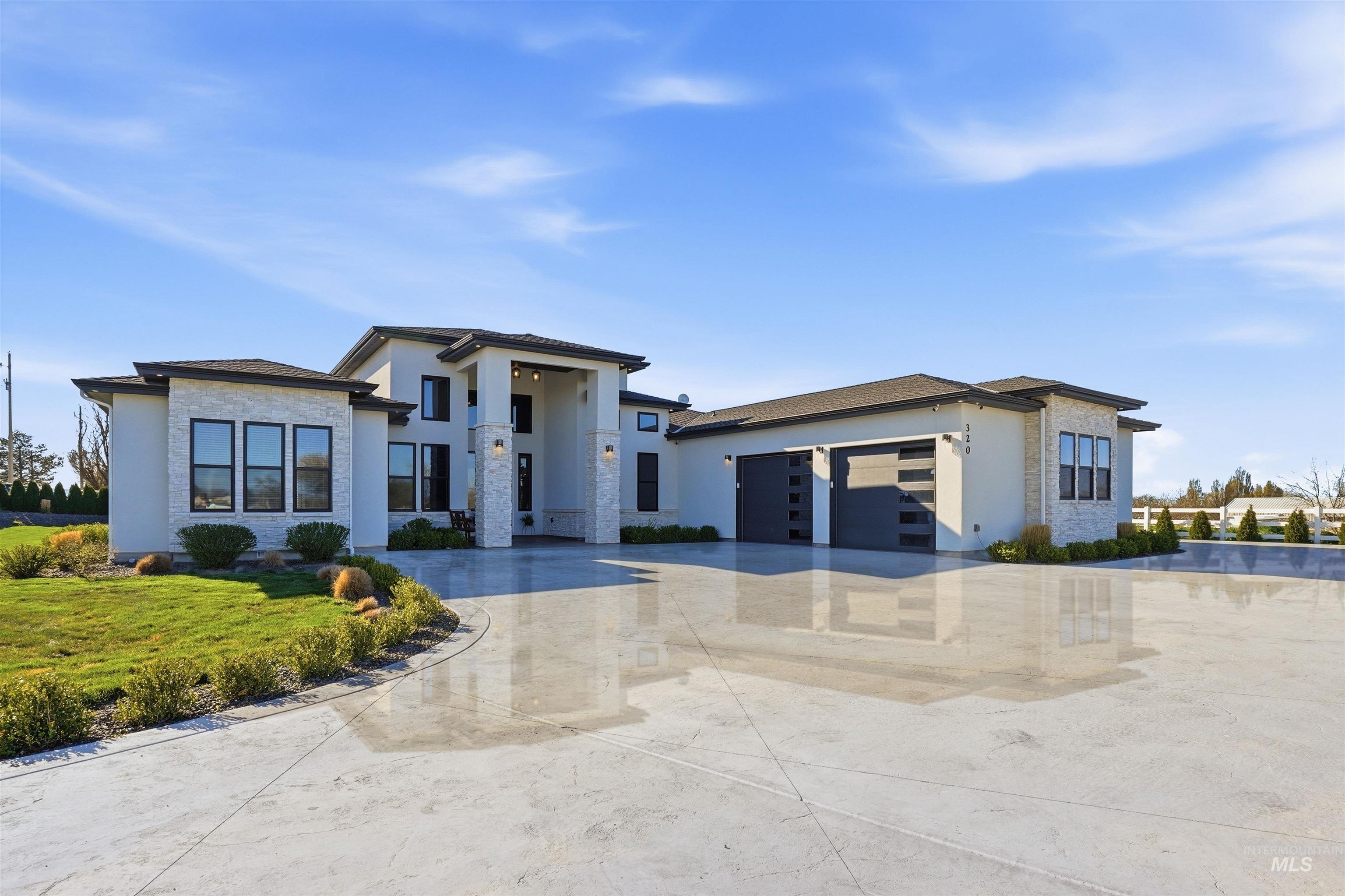 View of front of home featuring driveway, stucco siding, an attached garage, and a front lawn