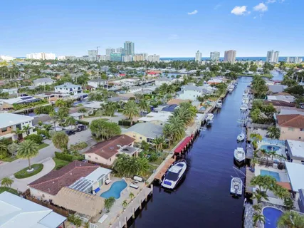 an aerial view of a city with lots of residential buildings ocean and mountain view in back