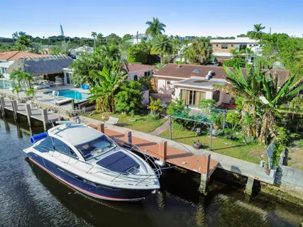 an aerial view of a house with a garden and lake view