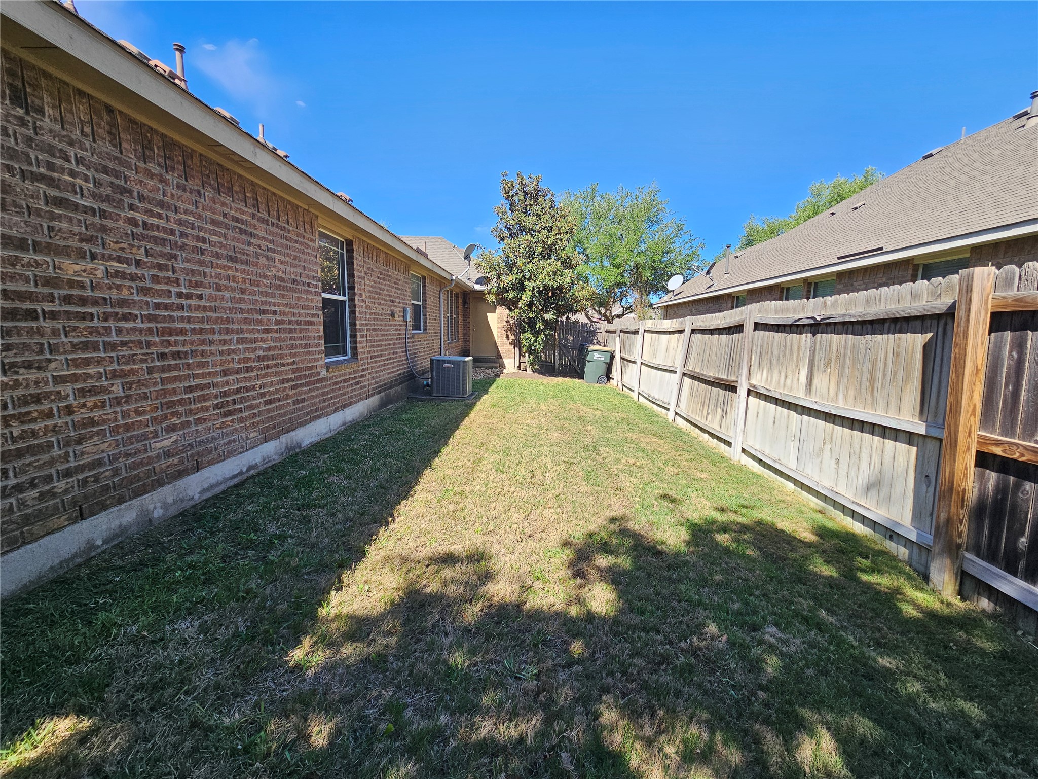 1323 Talley Loop Buda, TX 78610 - Photo 27 of 32 a view of backyard with large tree and wooden fence