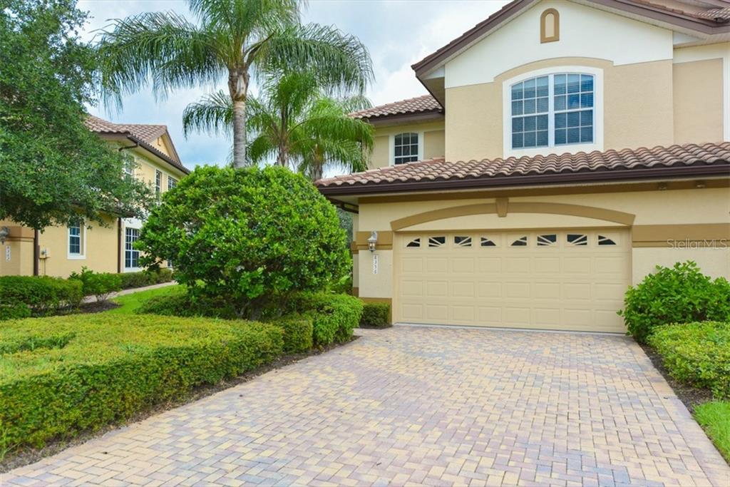 8356 Miramar Way, Unit 25 Lakewood Ranch, FL 34202 - Photo 1 of 1 a front view of a house with a garden and plants