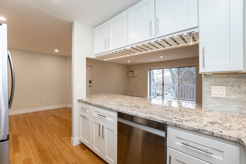31 Hamlin Lane, Unit A33 Needham, MA 02492 - Photo 3 of 15 a kitchen with granite countertop cabinets a sink and dishwasher