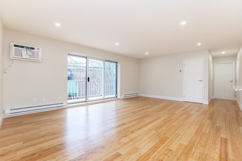 31 Hamlin Lane, Unit A33 Needham, MA 02492 - Photo 6 of 15 a view of an empty room with wooden floor and a window