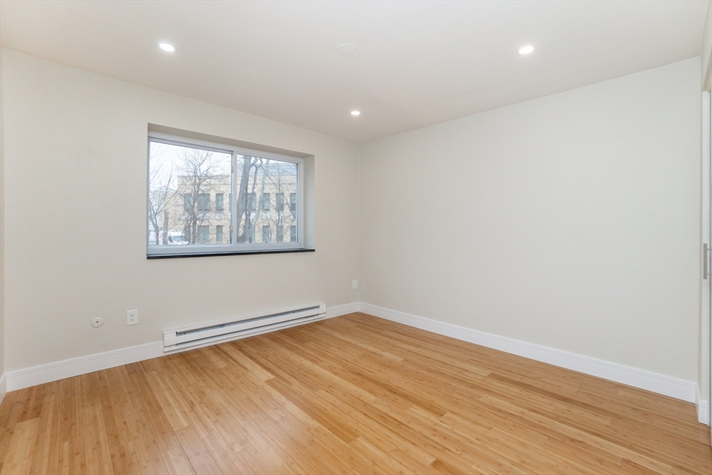 31 Hamlin Lane, Unit A33 Needham, MA 02492 - Photo 8 of 15 an empty room with wooden floor and windows