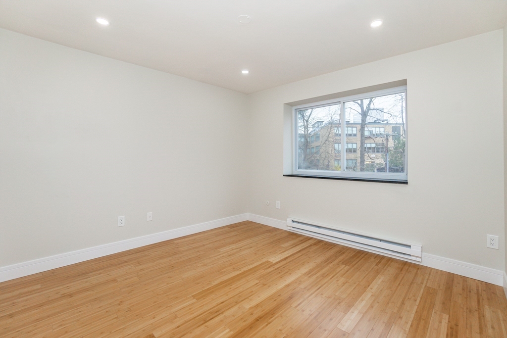 31 Hamlin Lane, Unit A33 Needham, MA 02492 - Photo 9 of 15 an empty room with wooden floor and windows