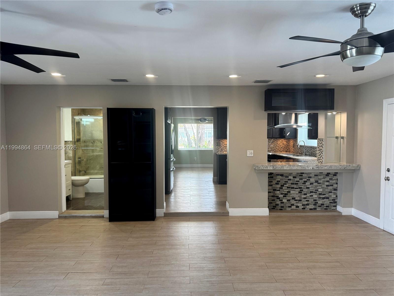 10760 Southwest 63rd Street Miami, FL 33173 - Photo 11 of 61 an empty room with wooden floor and windows