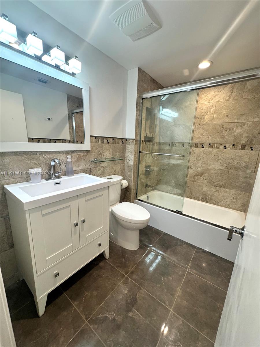 10760 Southwest 63rd Street Miami, FL 33173 - Photo 12 of 61 a bathroom with a double vanity sink mirror and toilet