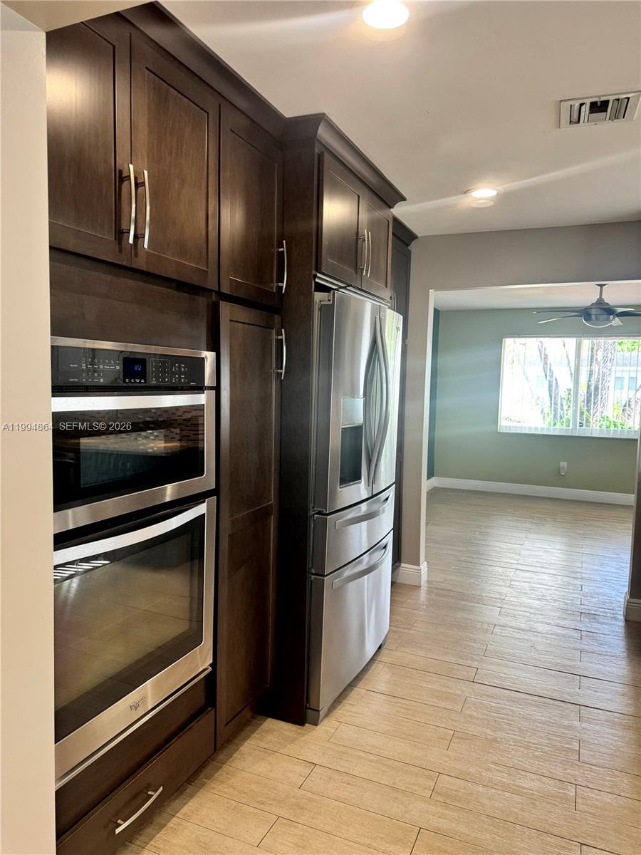 10760 Southwest 63rd Street Miami, FL 33173 - Photo 16 of 61 a kitchen with granite countertop stainless steel appliances and wooden floor