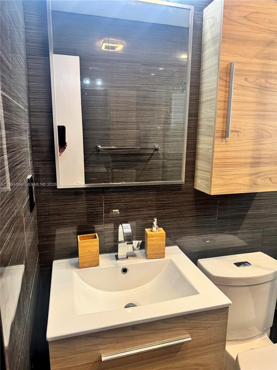 10760 Southwest 63rd Street Miami, FL 33173 - Photo 24 of 61 a bathroom with a sink a toilet and mirror