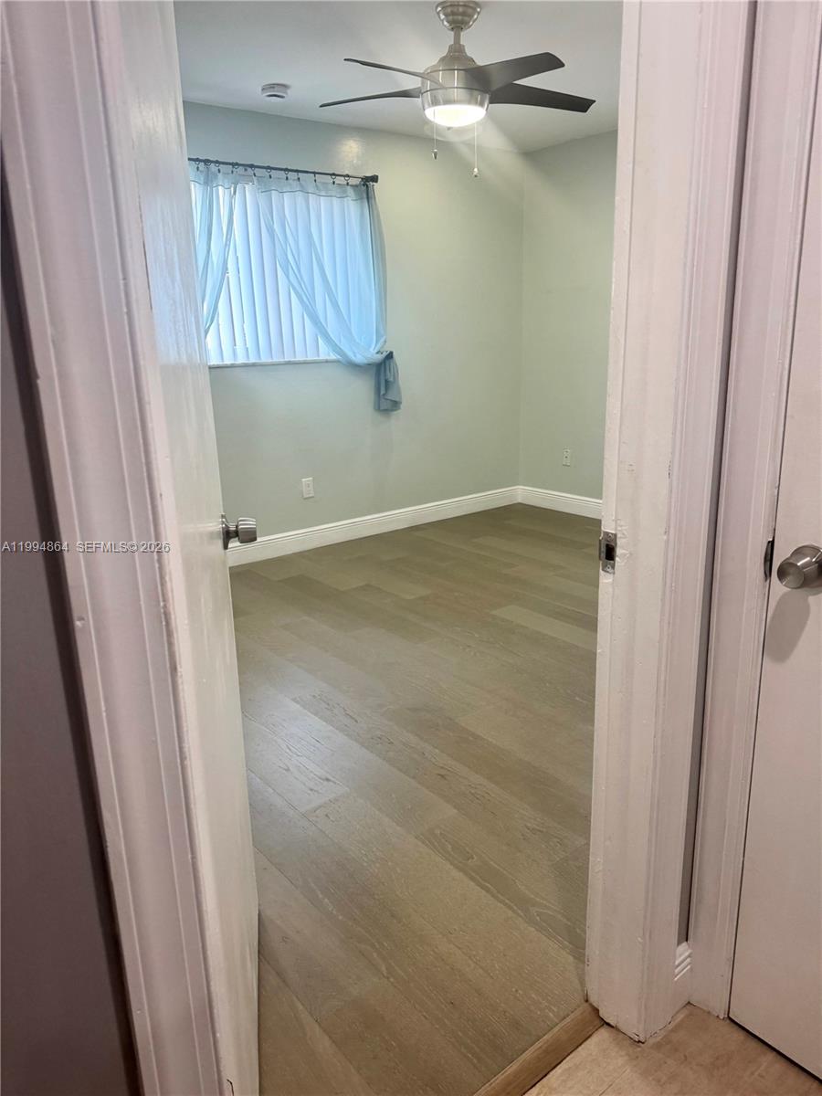 10760 Southwest 63rd Street Miami, FL 33173 - Photo 32 of 61 a view of an empty room with wooden floor and a window
