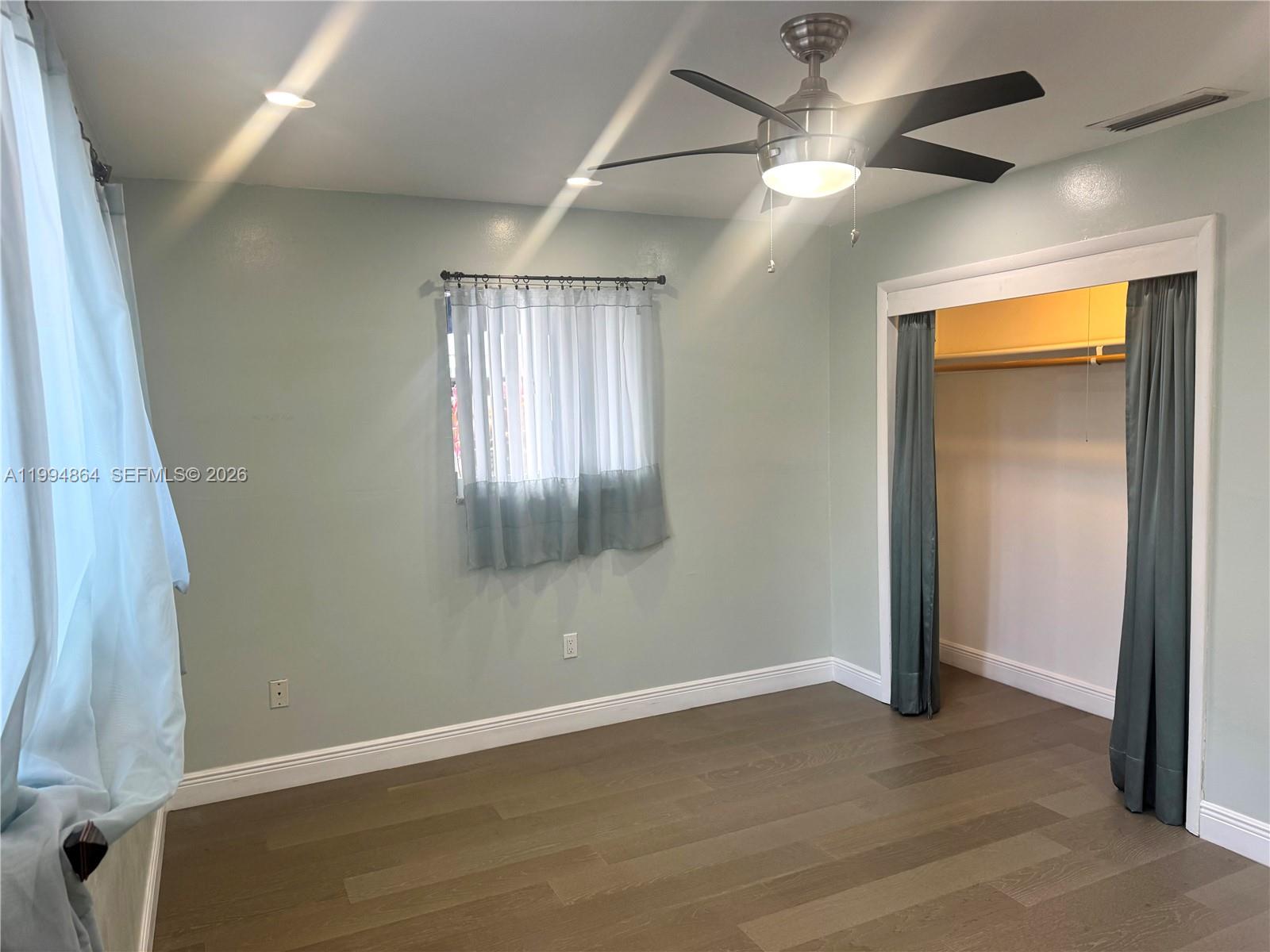 10760 Southwest 63rd Street Miami, FL 33173 - Photo 34 of 61 an empty room with wooden floor and a ceiling fan