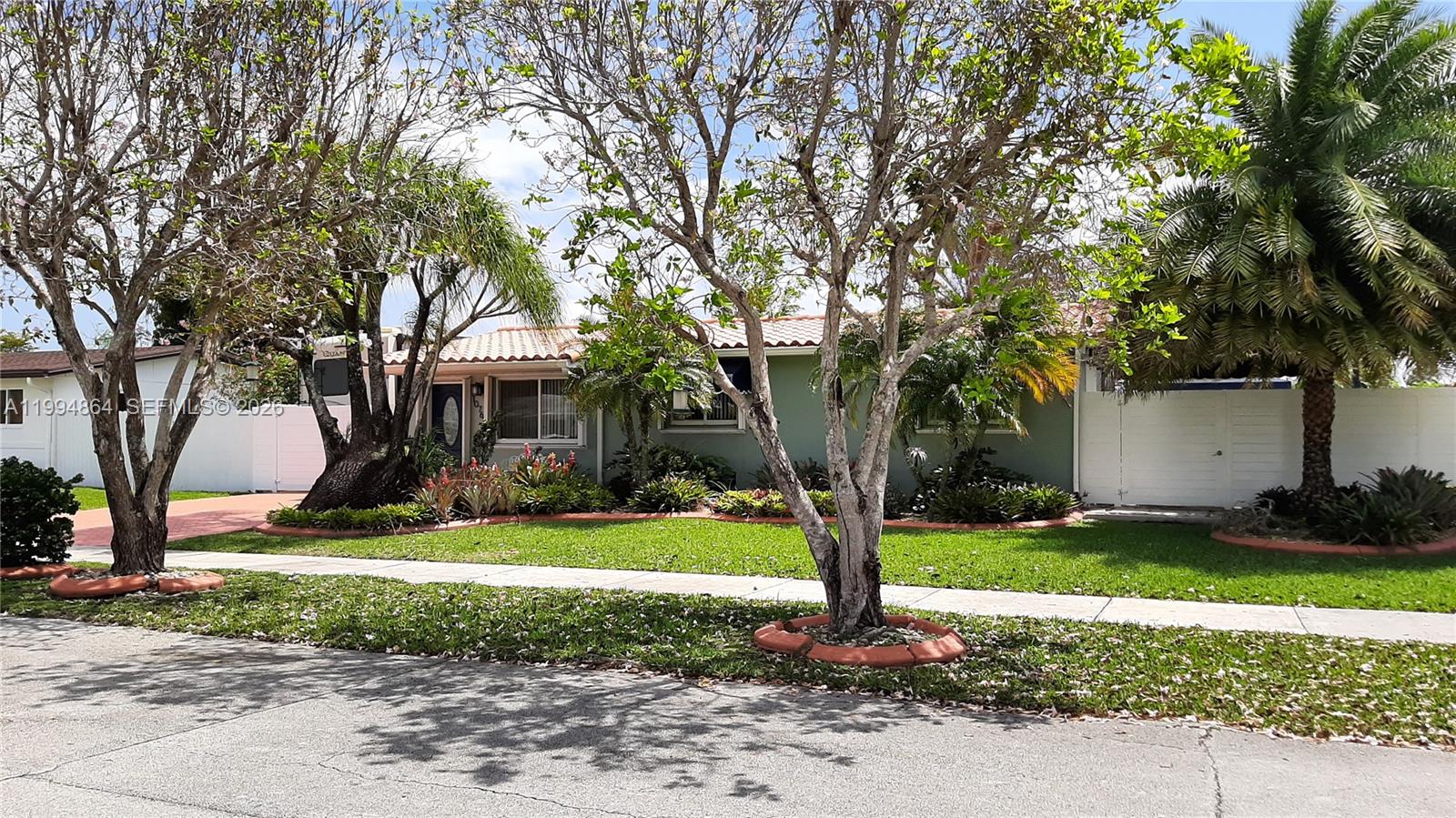 10760 Southwest 63rd Street Miami, FL 33173 - Photo 61 of 61 a front view of a house with garden and trees