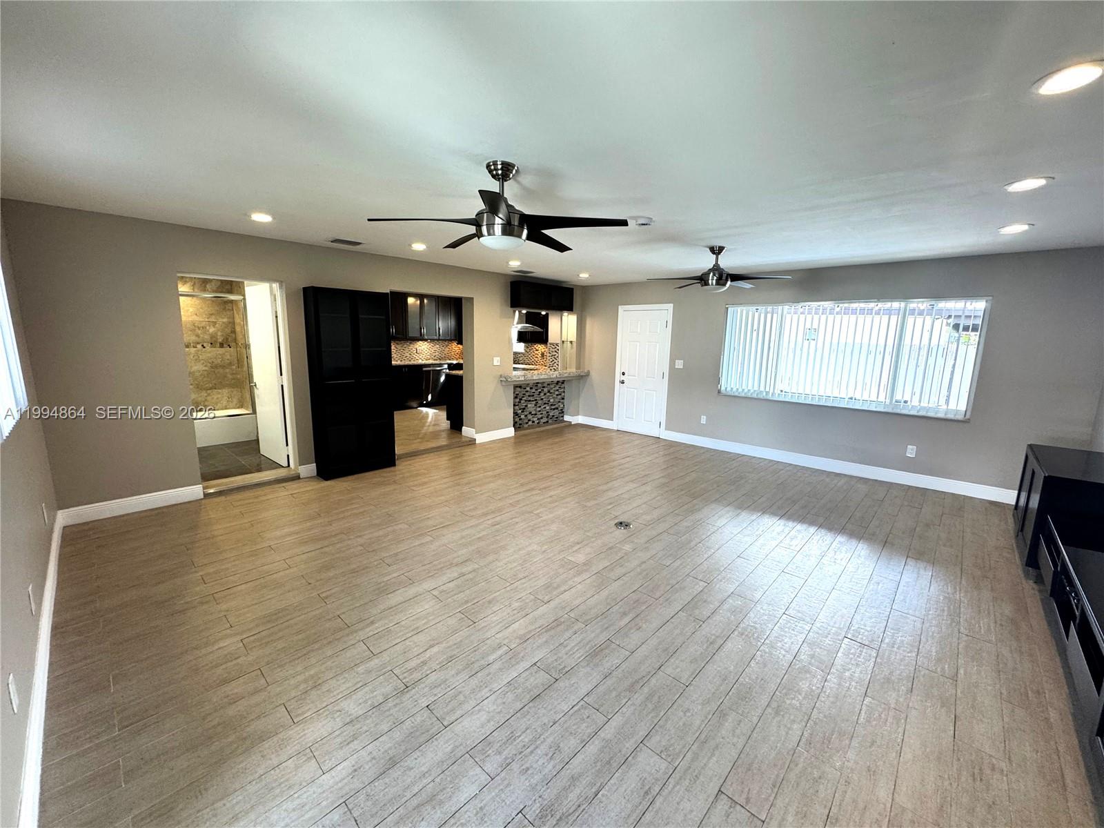 10760 Southwest 63rd Street Miami, FL 33173 - Photo 9 of 61 an empty room with wooden floor and windows