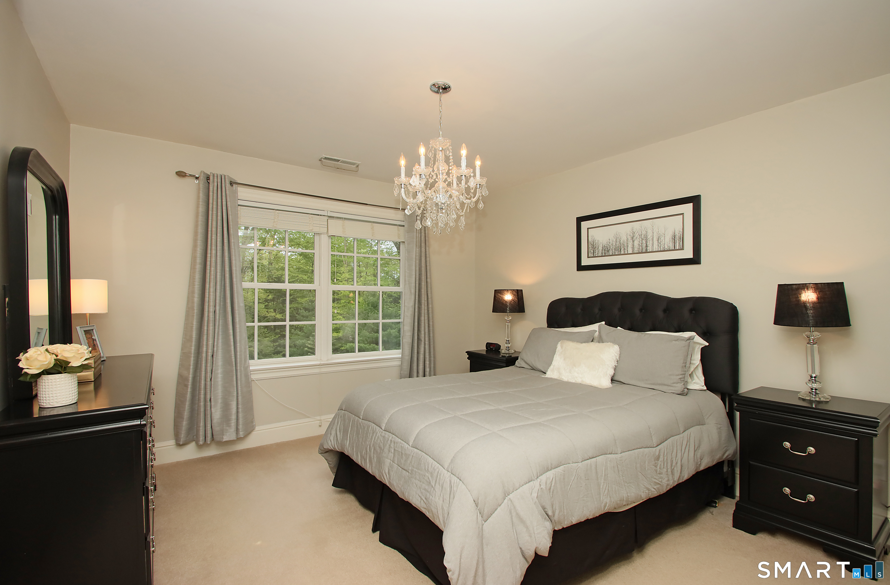 28 Quail Ridge Drive Avon, CT 06001 - Photo 34 of 40 a bedroom with a bed and a chandelier