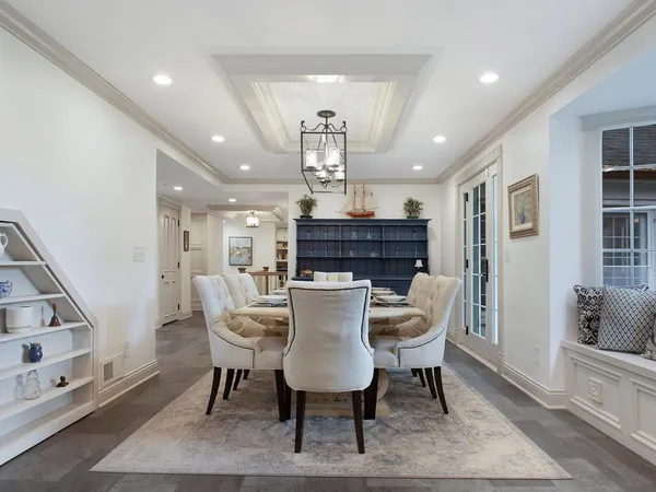 a view of a dining room with furniture a rug and wooden floor