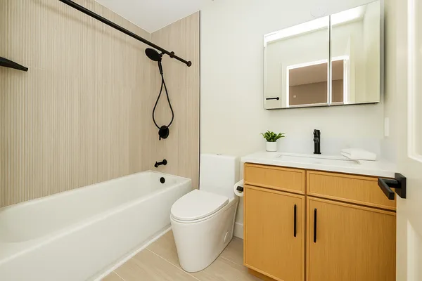 a bathroom with a white bath tub a sink and a mirror
