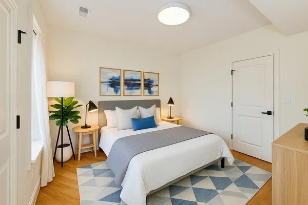a bedroom with a bed and a potted plant