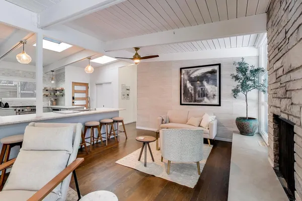 a living room with furniture and a view of kitchen