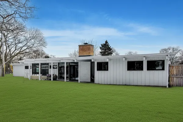 a view of a house with yard and sitting area