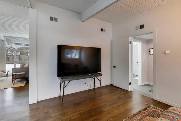 a view of a livingroom with wooden floor and furniture