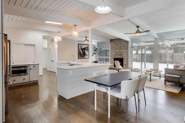 a open kitchen with stainless steel appliances kitchen island granite countertop a stove a sink a dining table and chairs