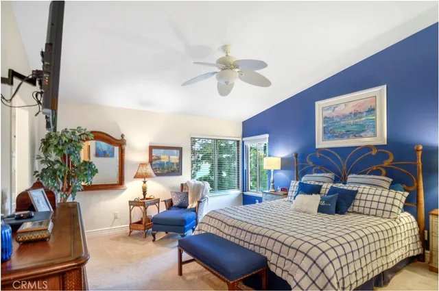 a bedroom with a bed a couch chairs and a chandelier