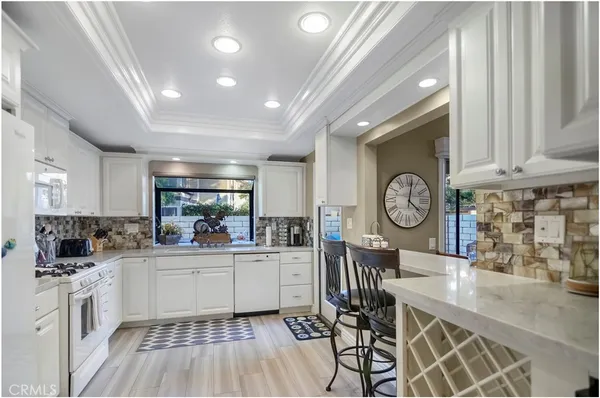 a very nice looking dining room with a large window and stainless steel appliances