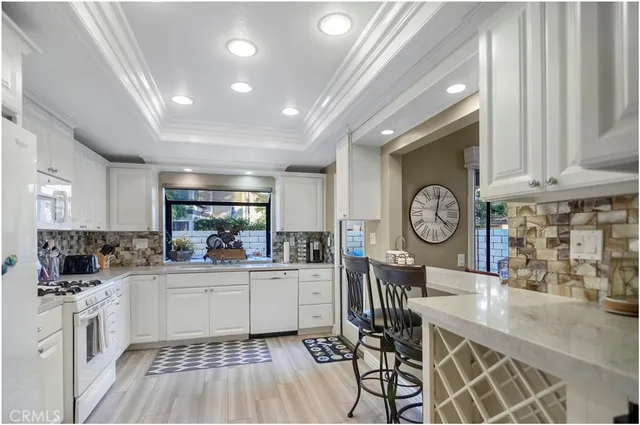 a very nice looking dining room with a large window and stainless steel appliances