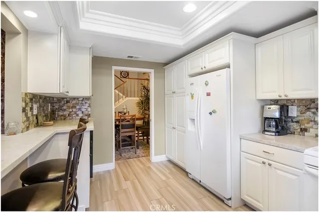 a kitchen with white cabinets and white appliances