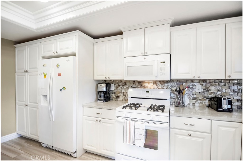 33766 Captains Lane, Unit 200 Dana Point, CA 92629 - Photo 10 of 38 a kitchen with white cabinets and white appliances